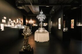 Vue de l'intérieur d'une pièce de l'espace Baccarat Musée & Café. On voit au centre de l'image un grand lustre en cristal.