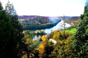 Vue depuis la chambre d'hôtes Les Vannes à Liverdun : on voit la Moselle en contrebas et des couleurs d'automne dans les arbres.