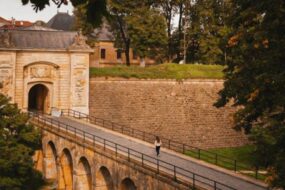 Une jeune femme marche sur les remparts Vauban de Longwy, devant la Porte de France.